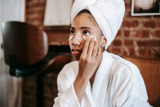 Seorang wanita muda dengan kulit sehat sedang mengaplikasikan serum anti-aging pada wajahnya, menunjukkan salah satu langkah penting dalam rutinitas perawatan kulit untuk menjaga keremajaan dan vitalitasnya. Produk anti-aging kini menjadi bagian tak terpisahkan dari gaya hidup modern untuk mengatasi tanda-tanda penuaan dini.