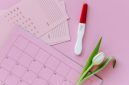 Seorang perempuan tersenyum saat meninjau kalender digitalnya, menunjukkan siklus haid yang teratur sebagai bagian dari gaya hidup sehat dan perhatian terhadap kesejahteraan diri.