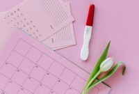 Seorang perempuan tersenyum saat meninjau kalender digitalnya, menunjukkan siklus haid yang teratur sebagai bagian dari gaya hidup sehat dan perhatian terhadap kesejahteraan diri.