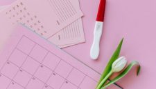 Seorang perempuan tersenyum saat meninjau kalender digitalnya, menunjukkan siklus haid yang teratur sebagai bagian dari gaya hidup sehat dan perhatian terhadap kesejahteraan diri.