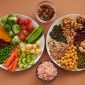 Piring yang berisi berbagai makanan bergizi seimbang, mencakup sayuran hijau segar, biji-bijian utuh, sumber protein seperti ikan, dan buah-buahan berwarna cerah, menunjukkan representasi visual dari pola makan sehat yang dianjurkan. Ilustrasi ini menekankan pentingnya variasi nutrisi dalam setiap sajian untuk mendukung kesehatan tubuh secara menyeluruh dan energi sepanjang hari.