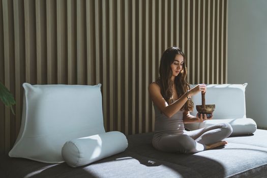 Seseorang sedang menikmati secangkir teh herbal sambil melihat pemandangan kota dari jendela, menunjukkan momen ketenangan dan mindfulness di tengah kesibukan perkotaan. Gambar ini merefleksikan pentingnya menciptakan ruang untuk relaksasi dalam gaya hidup sehat.