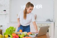 Seorang remaja perempuan sedang tersenyum sambil memegang semangkuk salad buah segar yang penuh warna, menunjukkan pilihan camilan sehat yang mendukung gaya hidup aktif dan penuh semangat. Gambar ini merepresentasikan pentingnya nutrisi seimbang bagi pertumbuhan remaja yang optimal.