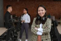 Seorang wanita profesional Indonesia tampak percaya diri dalam lingkungan kerja modern, mencerminkan semangat dan kemampuan adaptasi tinggi yang dibutuhkan untuk meraih kesuksesan karier. Gambar ini menggambarkan representasi wanita yang aktif dan berdaya di berbagai sektor industri saat ini.