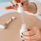 Seorang wanita sedang mengaplikasikan serum anti-aging di wajahnya, menunjukkan komitmen pada rutinitas perawatan kulit untuk menjaga keremajaan dan kesehatan kulit. Ilustrasi ini menggambarkan pentingnya perawatan teratur sebagai bagian dari upaya mendapatkan kulit awet muda.