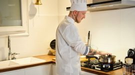 Seorang koki profesional bekerja di dapur yang tertata rapi, menggambarkan efisiensi dan perencanaan matang dalam mengelola waktu dan tugas. Konsep ini serupa dengan manajemen waktu produktif yang mengutamakan pengaturan prioritas dan alokasi blok waktu.