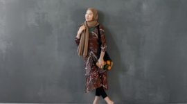 Seorang wanita berhijab berjalan anggun di tengah kota, menampilkan salah satu tren OOTD hijab tahun 2026 dengan paduan warna pastel dan potongan busana longgar yang modern. Gaya ini memancarkan keanggunan dan kenyamanan untuk aktivitas sehari-hari.