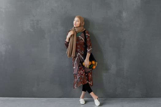 Seorang wanita berhijab berjalan anggun di tengah kota, menampilkan salah satu tren OOTD hijab tahun 2026 dengan paduan warna pastel dan potongan busana longgar yang modern. Gaya ini memancarkan keanggunan dan kenyamanan untuk aktivitas sehari-hari.