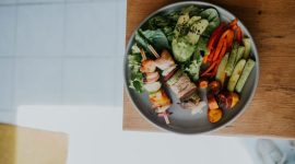 Sebuah piring berisi makanan seimbang yang kaya warna dan nutrisi, menampilkan sayuran segar, protein tanpa lemak, dan karbohidrat kompleks. Piring ini melambangkan pentingnya variasi dalam asupan makanan untuk menjaga kesehatan tubuh optimal setiap hari.