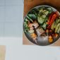 Sebuah piring berisi makanan seimbang yang kaya warna dan nutrisi, menampilkan sayuran segar, protein tanpa lemak, dan karbohidrat kompleks. Piring ini melambangkan pentingnya variasi dalam asupan makanan untuk menjaga kesehatan tubuh optimal setiap hari.