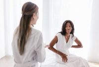 Seorang wanita terlihat lelah sambil memegang kepalanya, menggambarkan salah satu gejala umum anemia. Mengonsumsi makanan kaya zat besi dan berkonsultasi dengan dokter adalah langkah penting untuk mengembalikan kebugaran tubuh.