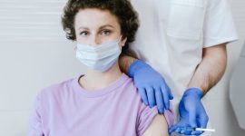 Seorang remaja perempuan sedang menerima suntikan vaksin HPV dari tenaga medis. Gambar ini melambangkan langkah penting dalam pencegahan kanker serviks dan penyakit terkait HPV lainnya.