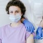 Seorang remaja perempuan sedang menerima suntikan vaksin HPV dari tenaga medis. Gambar ini melambangkan langkah penting dalam pencegahan kanker serviks dan penyakit terkait HPV lainnya.
