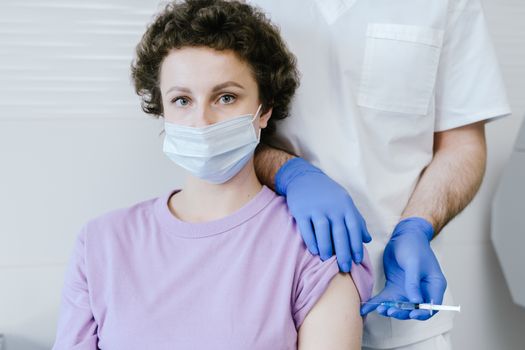 Seorang remaja perempuan sedang menerima suntikan vaksin HPV dari tenaga medis. Gambar ini melambangkan langkah penting dalam pencegahan kanker serviks dan penyakit terkait HPV lainnya.