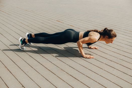 Seorang wanita sedang melakukan latihan angkat beban dengan *dumbbell* di sebuah pusat kebugaran, menunjukkan fokus pada pembentukan otot tangan dan bahu. Latihan resistensi merupakan kunci utama untuk membangun massa otot yang kuat dan kencang.