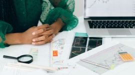 Seorang wanita tengah dengan percaya diri meninjau laporan keuangan digital, menunjukkan kemandirian dan kontrol atas perencanaan finansialnya. Gambar ini merepresentasikan kekuatan perempuan dalam mengelola aset demi masa depan yang lebih cerah.