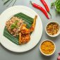 Sebuah piring berisi makanan seimbang dengan nasi merah, ikan bakar, tumis sayuran hijau, dan irisan buah segar yang melambangkan pilihan nutrisi optimal. Komposisi ini menunjukkan bagaimana hidangan khas Indonesia dapat diadaptasi untuk memenuhi kebutuhan gizi harian.