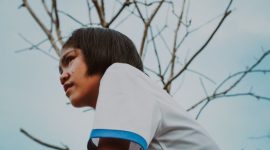 Seorang remaja terlihat termenung, mungkin sedang bergulat dengan pikirannya sendiri, menggambarkan kompleksitas tantangan kesehatan mental yang kerap dialami pada usia ini. Kehadiran orang dewasa yang suportif sangat dibutuhkan untuk mendampingi mereka melewati masa-masa sulit.