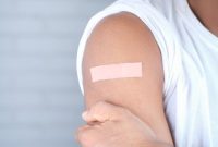 Seorang remaja perempuan sedang menerima suntikan vaksin HPV dari tenaga kesehatan, sebuah langkah penting dalam melindungi dirinya dari risiko kanker serviks di masa depan. Proses vaksinasi ini merupakan bagian dari upaya global untuk meningkatkan kesehatan masyarakat melalui pencegahan penyakit.