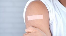 Seorang remaja perempuan sedang menerima suntikan vaksin HPV dari tenaga kesehatan, sebuah langkah penting dalam melindungi dirinya dari risiko kanker serviks di masa depan. Proses vaksinasi ini merupakan bagian dari upaya global untuk meningkatkan kesehatan masyarakat melalui pencegahan penyakit.