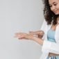 Seorang wanita dengan kulit wajah bersih dan glowing yang terpancar secara alami, menunjukkan hasil perawatan kulit konsisten serta gaya hidup sehat. Kilau sehat pada kulit merefleksikan hidrasi optimal dan regenerasi sel yang baik.