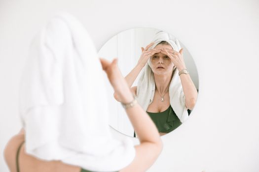 Seorang wanita mengaplikasikan tabir surya pada wajahnya di bawah sinar matahari, menunjukkan salah satu langkah penting dalam menjaga kesehatan kulit. Rutinitas perawatan yang konsisten adalah kunci utama untuk mendapatkan kulit wajah yang sehat dan tampak muda.