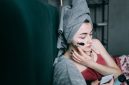 Seorang remaja perempuan sedang mengaplikasikan pembersih wajah yang lembut, menunjukkan pentingnya langkah awal dalam rutinitas perawatan kulit yang aman dan efektif. Pemilihan produk yang tepat menjadi kunci utama untuk menjaga kesehatan kulit muda dari iritasi.