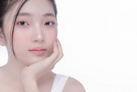 Seorang perempuan dengan kulit bercahaya alami di bawah sinar matahari pagi, menunjukkan hasil perawatan kulit yang konsisten dan gaya hidup sehat. Wajahnya memancarkan keindahan murni tanpa riasan berlebihan, memperlihatkan tekstur kulit yang halus dan merata.