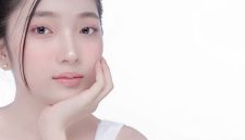 Seorang perempuan dengan kulit bercahaya alami di bawah sinar matahari pagi, menunjukkan hasil perawatan kulit yang konsisten dan gaya hidup sehat. Wajahnya memancarkan keindahan murni tanpa riasan berlebihan, memperlihatkan tekstur kulit yang halus dan merata.