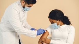 Seorang dokter sedang memberikan penjelasan mengenai pentingnya vaksinasi HPV kepada seorang remaja putri, menekankan bahwa imunisasi ini adalah investasi kesehatan jangka panjang yang krusial.