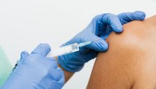 Seorang dokter sedang memberikan penjelasan mengenai pentingnya vaksin HPV kepada seorang perempuan muda, menekankan peran vitalnya dalam pencegahan kanker serviks. Ilustrasi ini menggambarkan momen edukasi kesehatan yang krusial untuk melindungi masa depan perempuan dari penyakit mematikan.