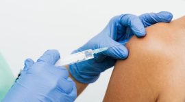 Seorang dokter sedang memberikan penjelasan mengenai pentingnya vaksin HPV kepada seorang perempuan muda, menekankan peran vitalnya dalam pencegahan kanker serviks. Ilustrasi ini menggambarkan momen edukasi kesehatan yang krusial untuk melindungi masa depan perempuan dari penyakit mematikan.