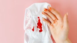 Seorang perempuan sedang mencatat siklus menstruasinya pada kalender, menunjukkan pentingnya memantau kesehatan reproduksi secara berkala. Pemantauan ini membantu memahami pola tubuh dan mengidentifikasi potensi masalah lebih awal.