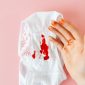 Seorang perempuan sedang mencatat siklus menstruasinya pada kalender, menunjukkan pentingnya memantau kesehatan reproduksi secara berkala. Pemantauan ini membantu memahami pola tubuh dan mengidentifikasi potensi masalah lebih awal.