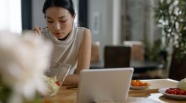 Remaja putri tersenyum cerah sambil menikmati sepiring salad segar penuh warna di luar ruangan, menunjukkan pilihan makanan sehat yang mendukung gaya hidup aktif dan penuh energi. Gambar ini mewakili pentingnya nutrisi seimbang untuk pertumbuhan dan kesejahteraan remaja.