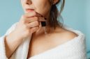Seorang wanita mengaplikasikan serum vitamin ke wajahnya, menunjukkan momen penting dalam rutinitas perawatan kulit untuk mendapatkan nutrisi optimal. Penggunaan serum secara teratur dapat membantu kulit tampak lebih cerah dan sehat dari waktu ke waktu.