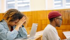 Seorang mahasiswa tampak beristirahat sejenak di tengah tumpukan buku, merefleksikan pentingnya menjaga keseimbangan dan kesehatan mental di antara padatnya jadwal perkuliahan. Momen relaksasi seperti ini sangat dibutuhkan untuk mengisi ulang energi dan mengurangi tingkat stres.