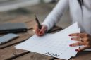Seorang wanita tengah memeriksa kalender menstruasi, menggarisbawahi pentingnya melacak siklus sebagai bagian dari pemantauan kesehatan reproduksi secara menyeluruh. Keteraturan siklus haid adalah indikator vital yang mencerminkan keseimbangan tubuh dan gaya hidup yang dijalani.
