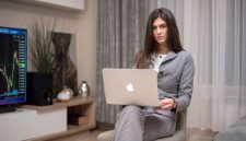 Seorang wanita tengah serius meninjau laporan keuangan pada laptopnya, menunjukkan fokus dan dedikasi dalam mengelola aset pribadi demi masa depan yang stabil. Ilustrasi ini merepresentasikan semangat perempuan modern yang proaktif dalam perencanaan finansial mereka.