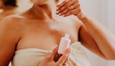 Seorang wanita mengaplikasikan serum vitamin C pada wajahnya, menunjukkan langkah penting dalam rutinitas perawatan kulit untuk mendapatkan kulit yang lebih cerah dan sehat. Penggunaan serum secara teratur dapat membantu menutrisi kulit secara mendalam dan melindunginya dari berbagai faktor lingkungan yang merusak.